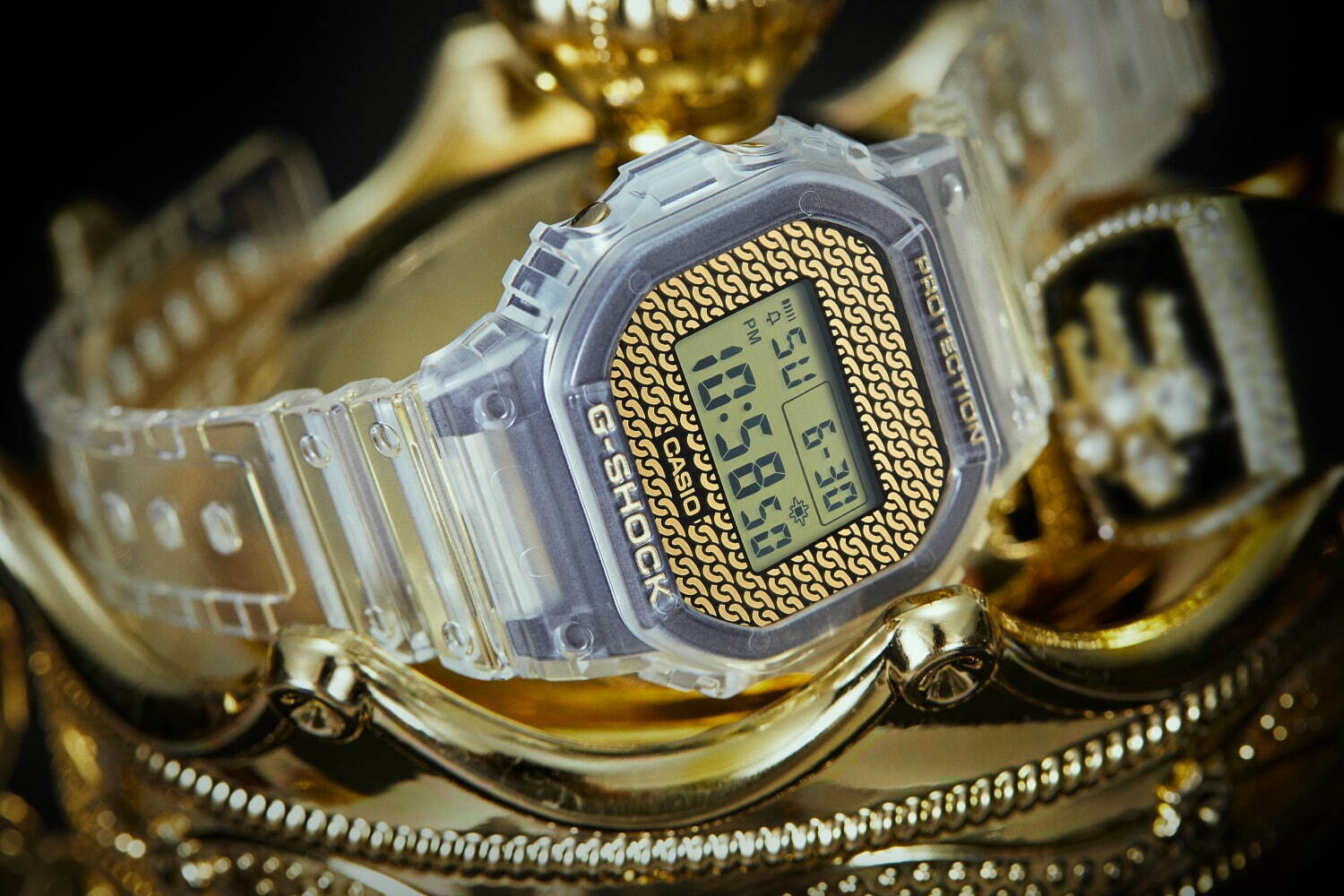 G Shock チェーンモチーフ 文字板のゴールド腕時計 付け替え可能なクリアバンド ベゼル付属 ファッションプレス